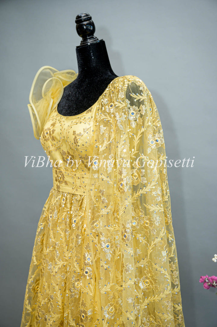 Yellow Net Embroidered One Side Cape Sleeve Gown